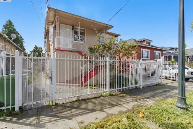 a view of a house with a small yard and wooden fence