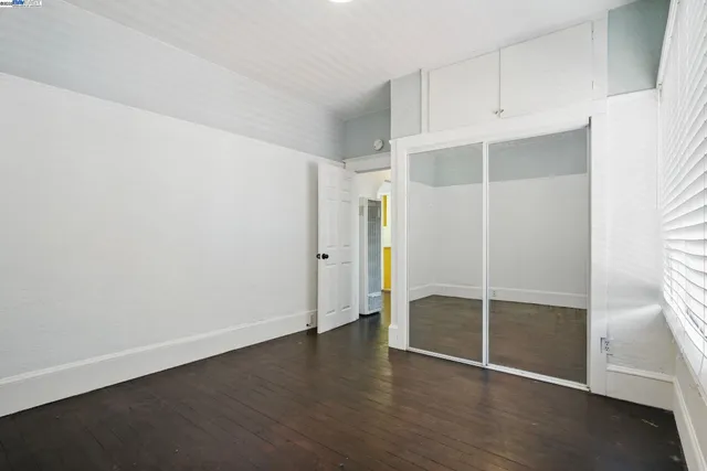 an empty room with wooden floor and closet