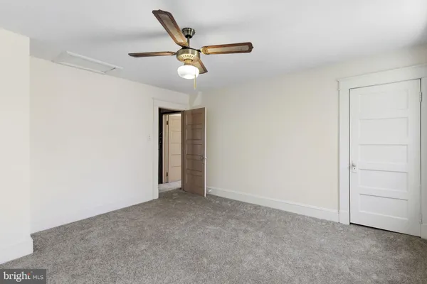 a view of an empty room and chandelier fan