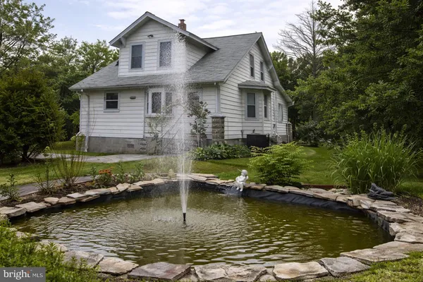 a view of house with swimming pool and yard
