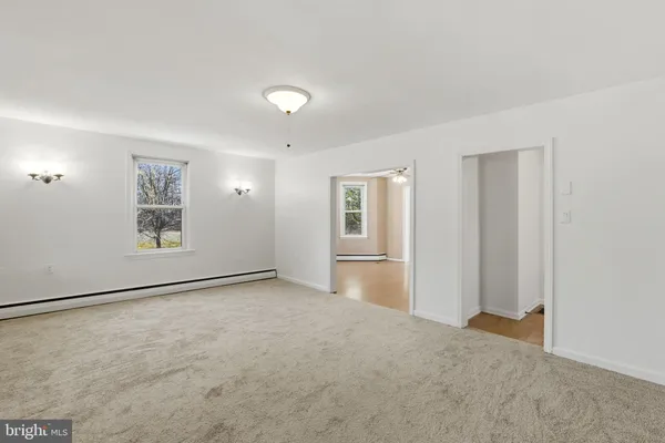 an empty room with windows and closet