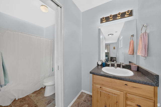 297 West Bricker Road Draper, UT 84020 - Photo 20 of 44 Bathroom featuring a wood-finish vanity with a built-in sink and dark countertop
