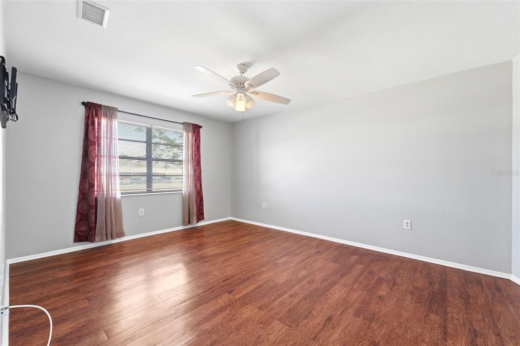 5364 Deltona Boulevard Spring Hill, FL 34606 - Photo 11 of 33 a view of an empty room with a window and wooden floor