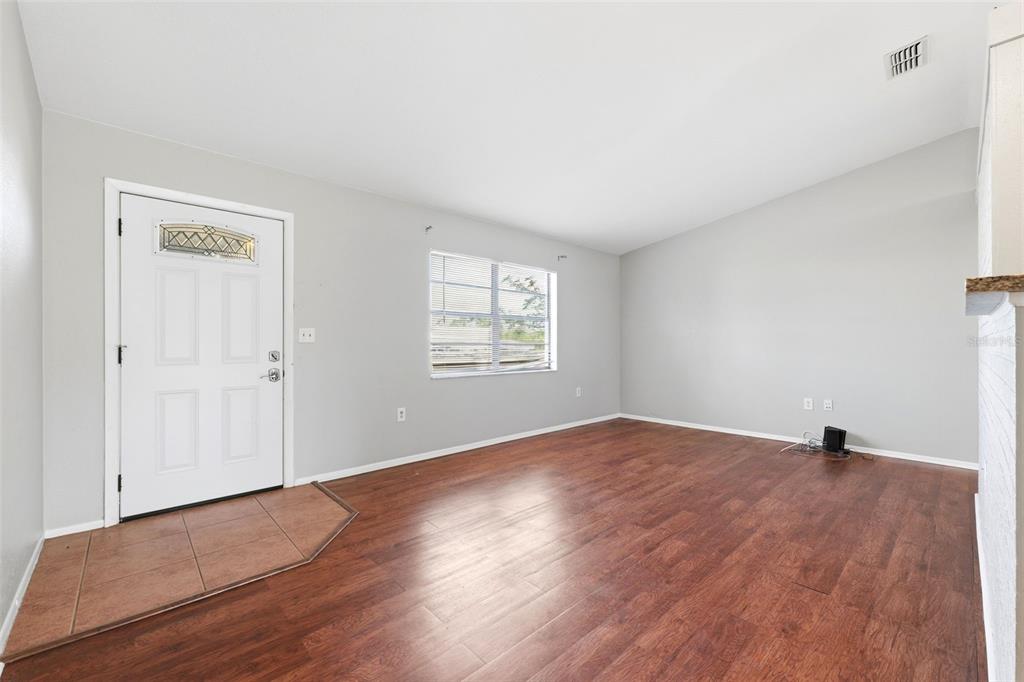 5364 Deltona Boulevard Spring Hill, FL 34606 - Photo 5 of 33 an empty room with wooden floor and windows