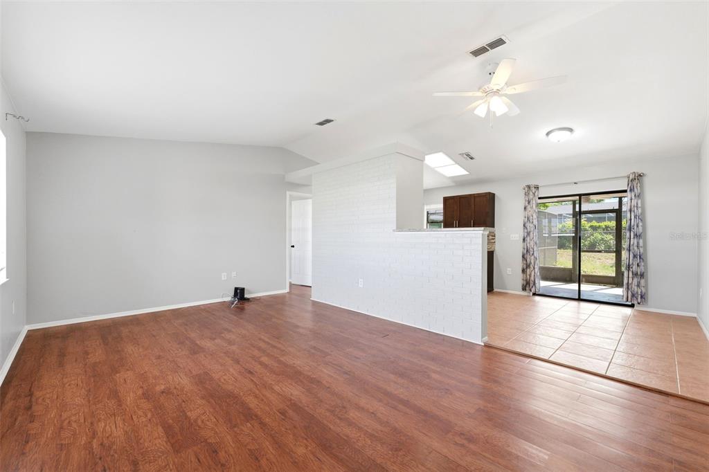 5364 Deltona Boulevard Spring Hill, FL 34606 - Photo 6 of 33 a view of an empty room with wooden floor and a window