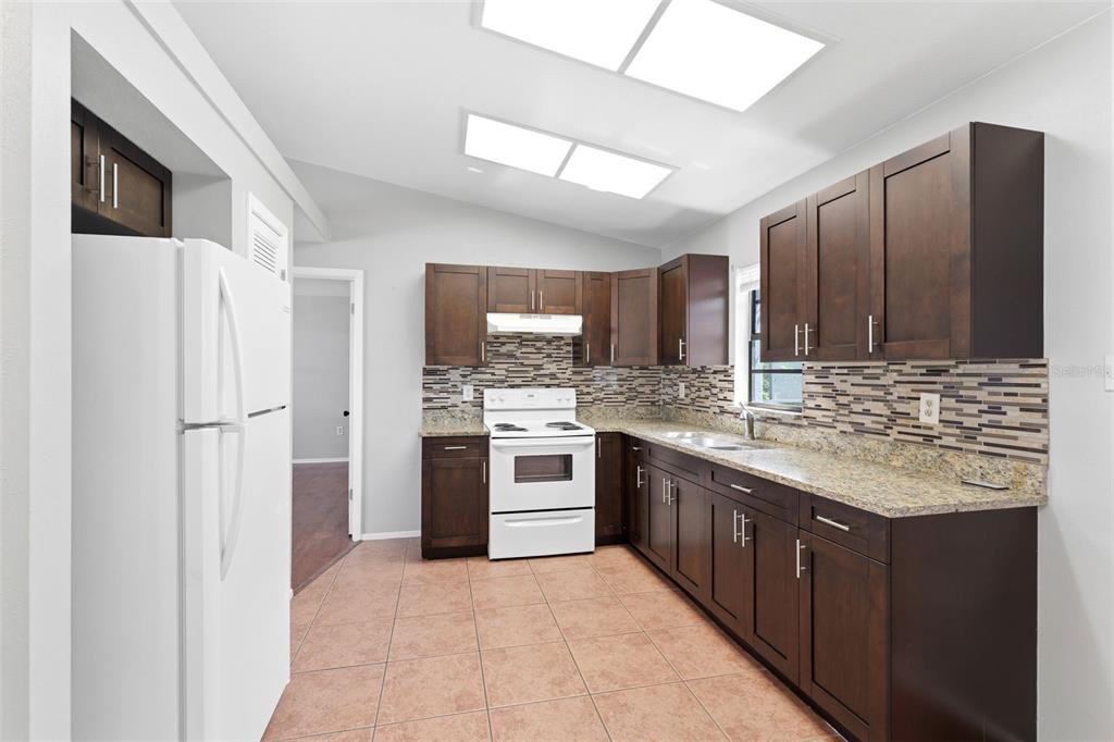 5364 Deltona Boulevard Spring Hill, FL 34606 - Photo 7 of 33 a kitchen with stainless steel appliances granite countertop a refrigerator and a sink