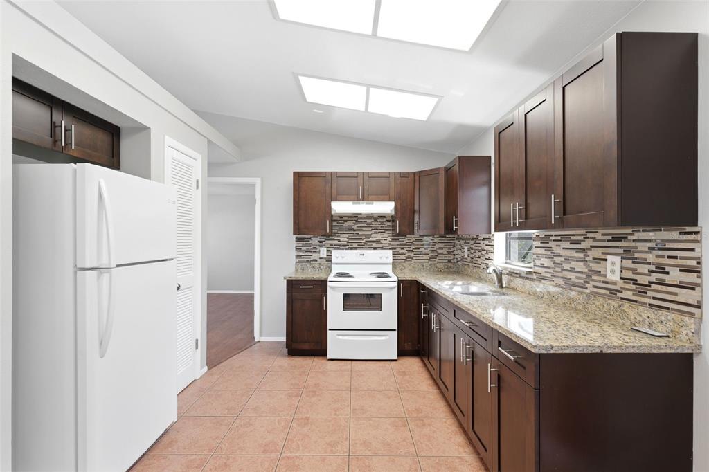 5364 Deltona Boulevard Spring Hill, FL 34606 - Photo 8 of 33 a kitchen with stainless steel appliances granite countertop a sink stove and refrigerator