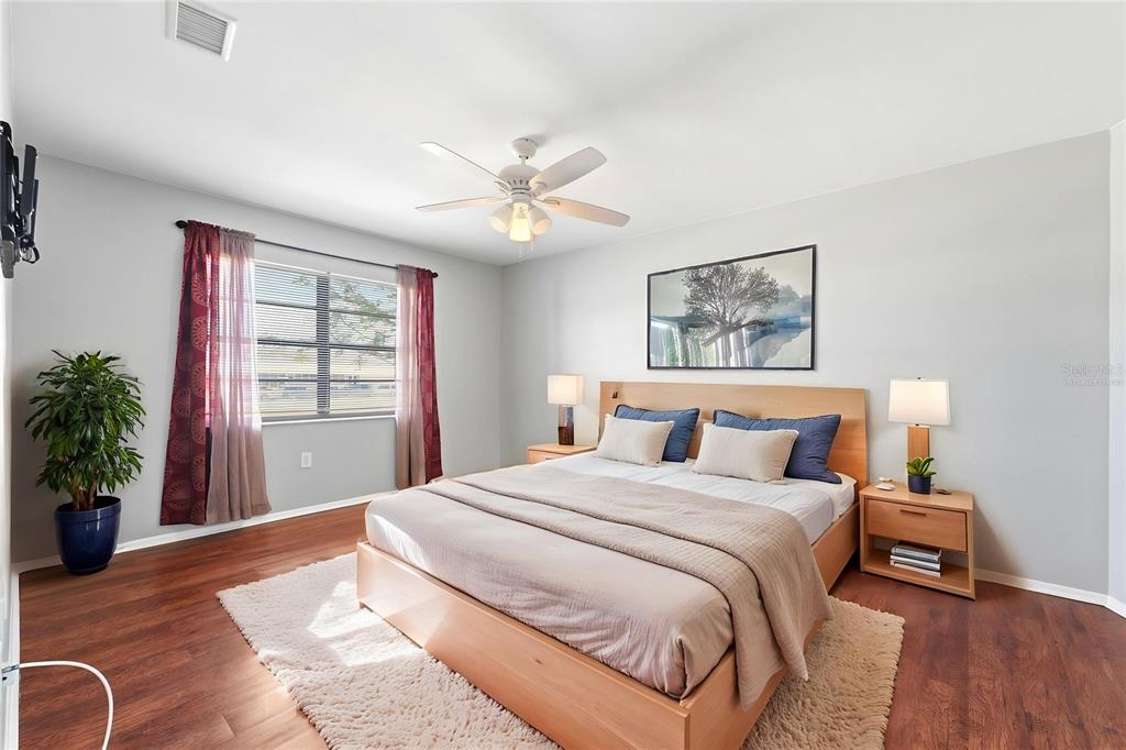 5364 Deltona Boulevard Spring Hill, FL 34606 - Photo 9 of 33 a spacious bedroom with a large bed and a chandelier
