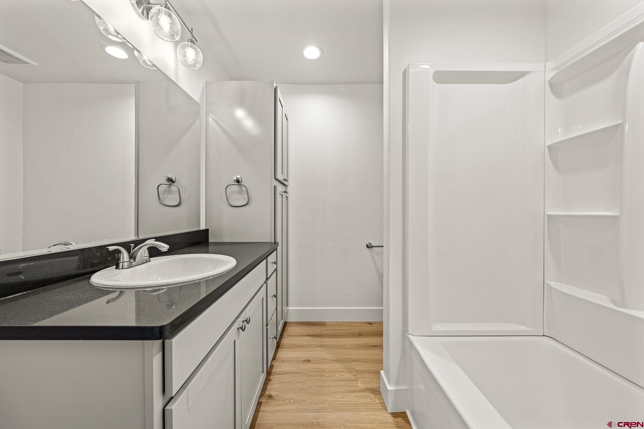 116 Senica Street Bayfield, CO 81122 - Photo 18 of 28 a bathroom with a granite countertop sink a toilet a mirror and shower