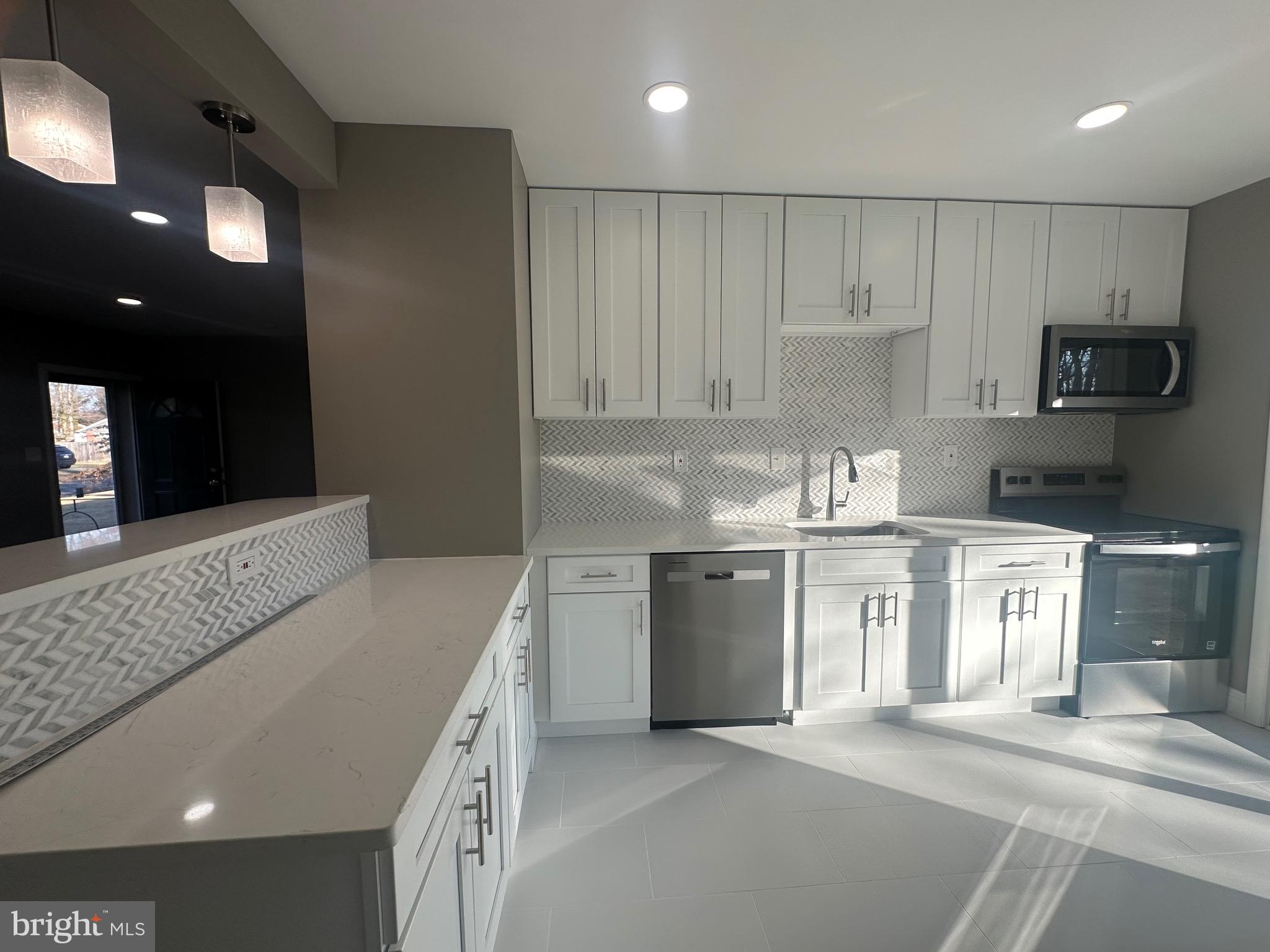 1401 Madison Drive Fort Washington, MD 20744 - Photo 7 of 30 a kitchen with kitchen island granite countertop a sink and stove top oven