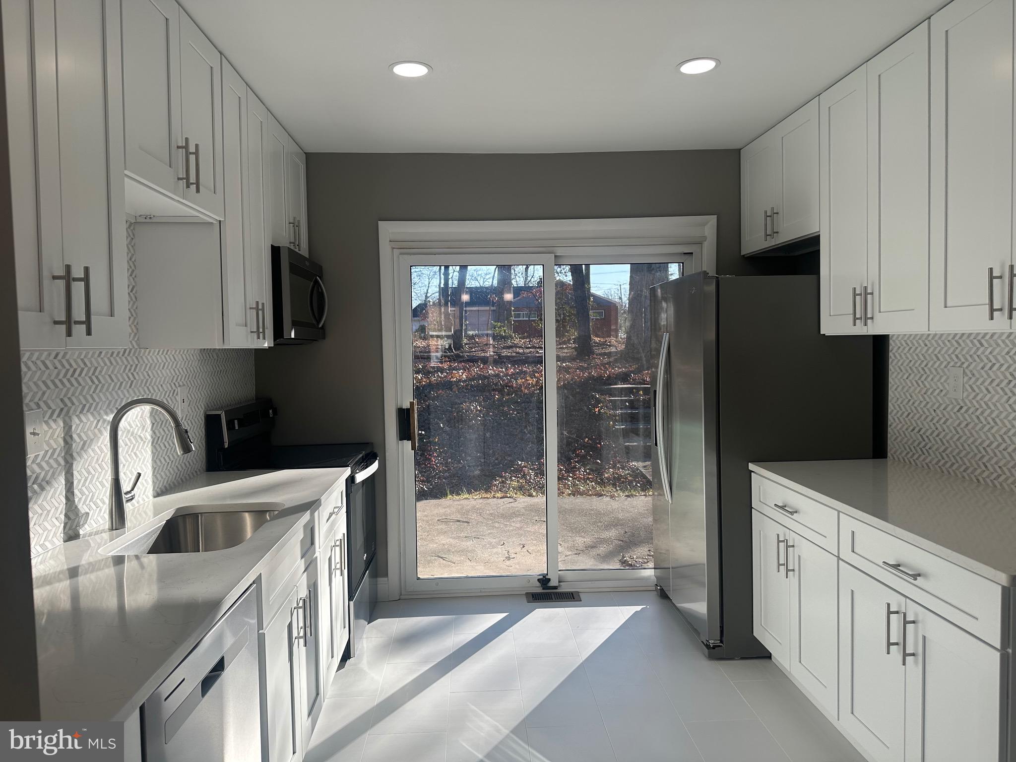 1401 Madison Drive Fort Washington, MD 20744 - Photo 8 of 30 a kitchen with stainless steel appliances granite countertop a refrigerator a sink a stove and white cabinets