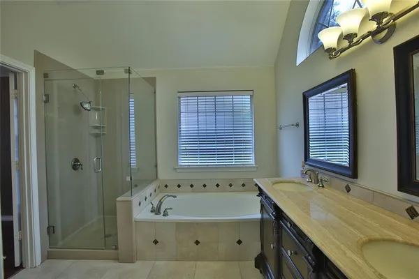 a bathroom with a granite countertop sink a large mirror and a bathtub