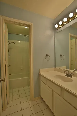 a spacious bathroom with a granite countertop sink a mirror and shower