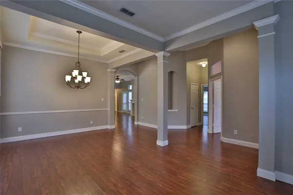 a view of an empty room with wooden floor