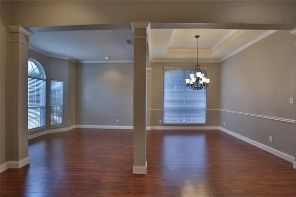 a view of a hallway with wooden floor and a window