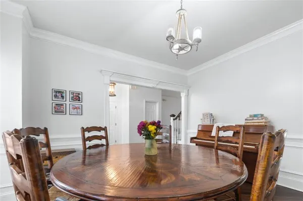 a dining room with furniture a chandelier and wooden floor