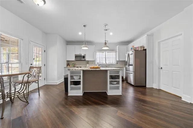 a kitchen with a refrigerator and a stove top oven