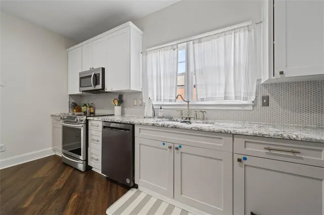 a kitchen with granite countertop white cabinets and white appliances