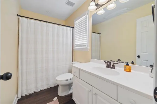 a bathroom with a sink a toilet and shower curtain