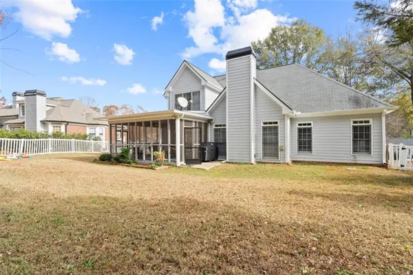 a view of a yard in front of a house with a large tree