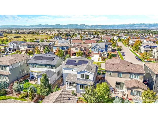 an aerial view of a house with a yard garage and lake view in back