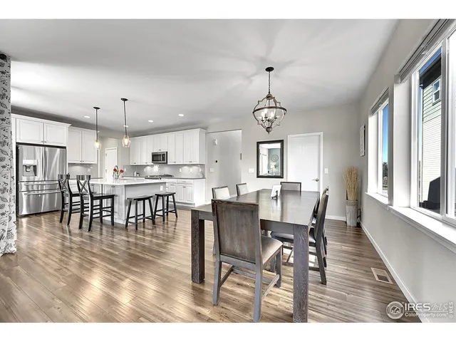 a view of dining room and livingroom with furniture wooden floor a chandelier