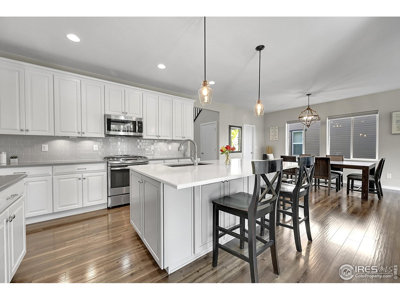 68 Starlight Circle Erie, CO 80516 - Photo 9 of 50 a kitchen with stainless steel appliances kitchen island a table chairs and a refrigerator