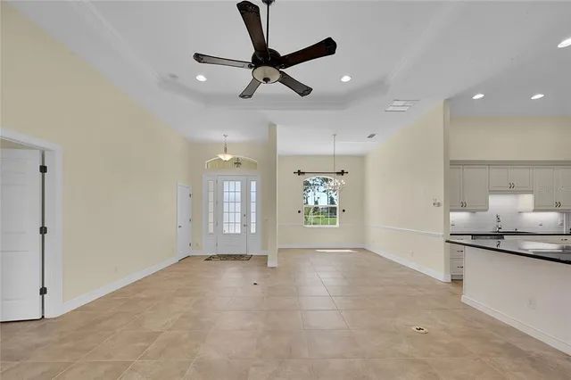 an empty room with a fan & a window