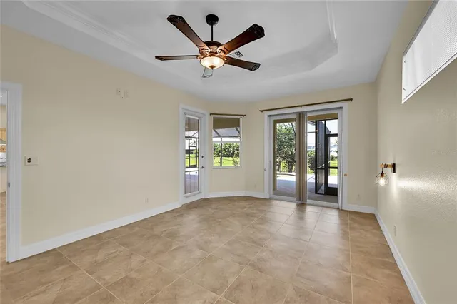 an empty room with windows and chandelier fan