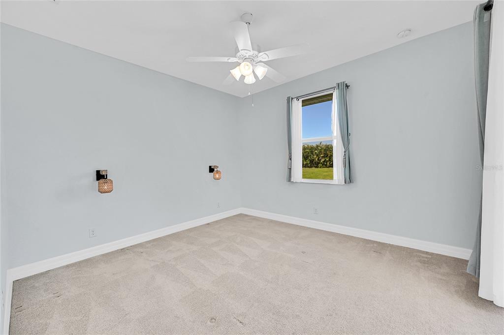 233 Fairway Road Rotonda West, FL 33947 - Photo 38 of 63 an empty room with windows and chandelier fan