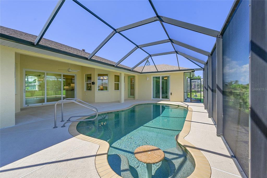 233 Fairway Road Rotonda West, FL 33947 - Photo 6 of 63 a view of a patio with table and chairs under an umbrella