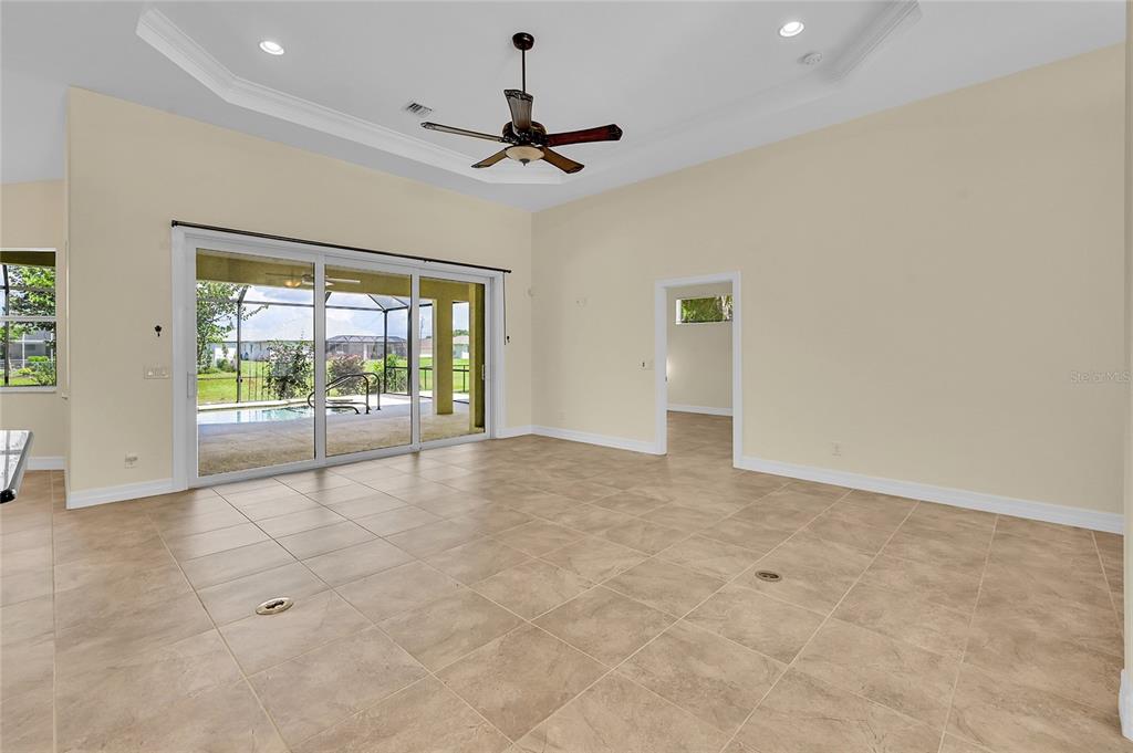 233 Fairway Road Rotonda West, FL 33947 - Photo 9 of 63 an empty room with chandelier fan and windows