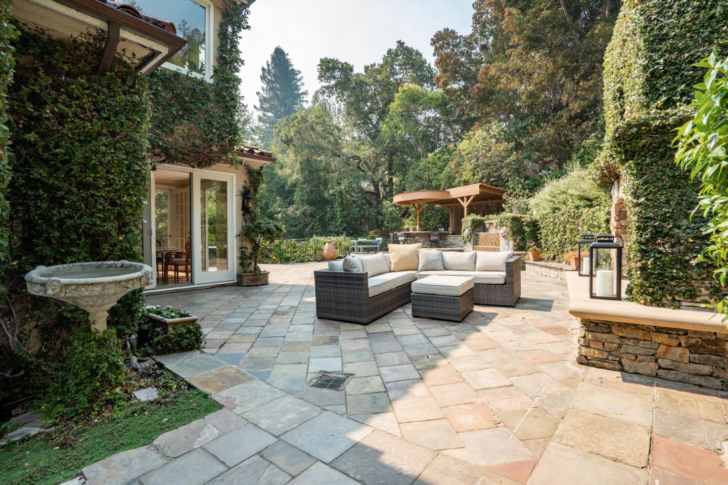 843 Chiltern Road Hillsborough, CA 94010 - Photo 83 of 94 a view of a patio with table and chairs potted plants with large tree