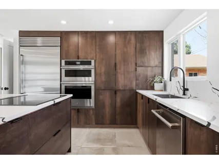 a kitchen with kitchen island granite countertop a sink stove and refrigerator