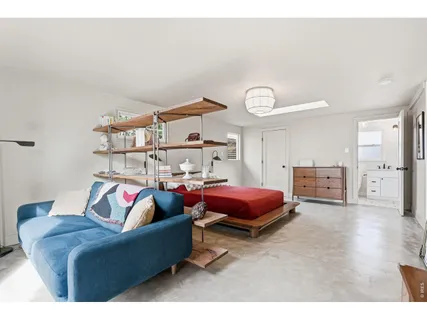 a living room with furniture a rug and white walls