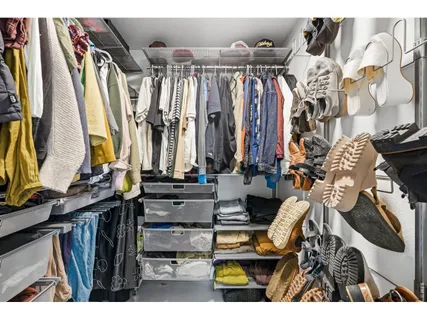 a view of walk in closet with clothes and shoes