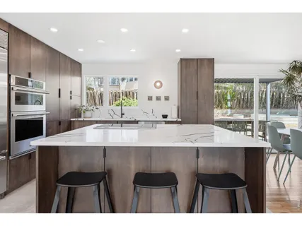 a kitchen with a sink and chairs