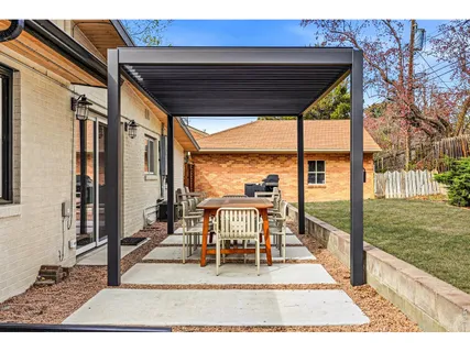 a view of a patio with table and chairs floor to ceiling window with wooden fence