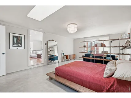 a bedroom with a large bed and a chandelier