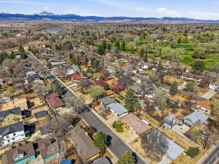 an aerial view of residential houses with outdoor space and trees
