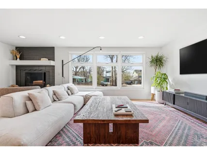 a living room with furniture a flat screen tv and a large window