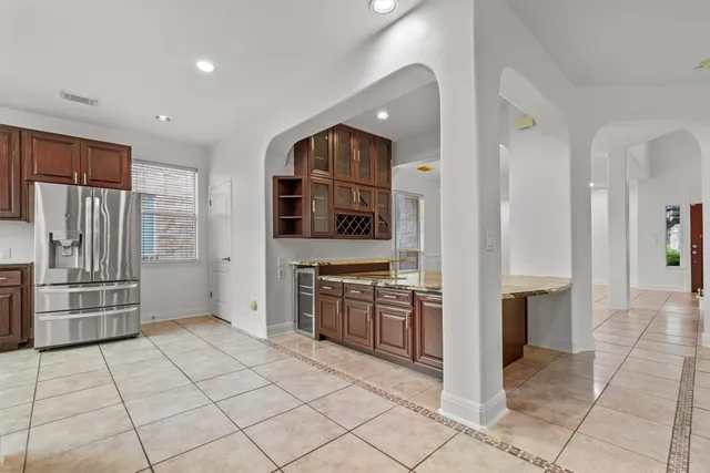 a kitchen with granite countertop kitchen island wooden cabinets and stainless steel appliances