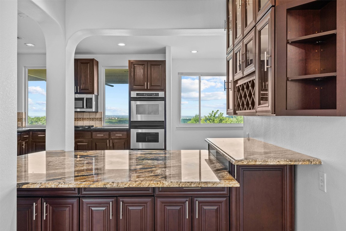 5724 Brittlyns Court Austin, TX 78730 - Photo 15 of 40 a kitchen with granite countertop kitchen island wooden cabinets and stainless steel appliances