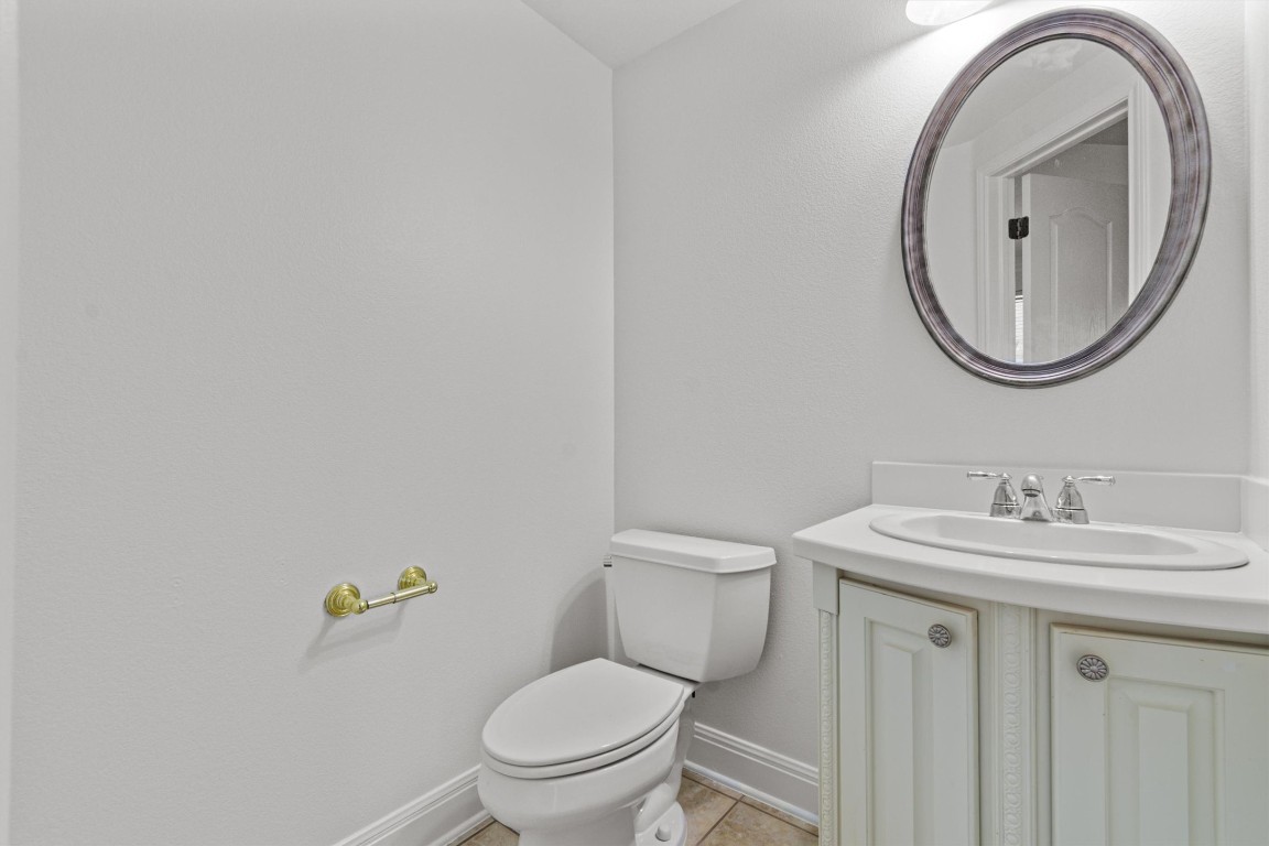 5724 Brittlyns Court Austin, TX 78730 - Photo 19 of 40 a bathroom with a granite countertop toilet a sink and a mirror