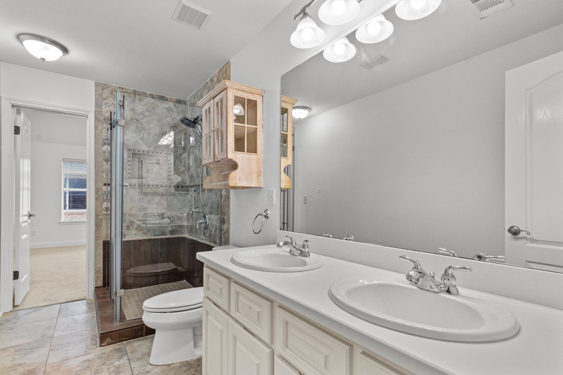5724 Brittlyns Court Austin, TX 78730 - Photo 29 of 40 a bathroom with a sink a toilet and shower