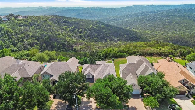 an aerial view of house with yard and mountain view in back