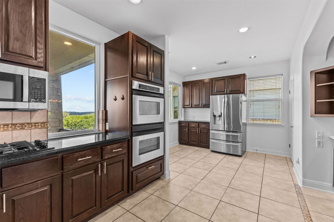 5724 Brittlyns Court Austin, TX 78730 - Photo 10 of 40 a kitchen with granite countertop a refrigerator and a sink