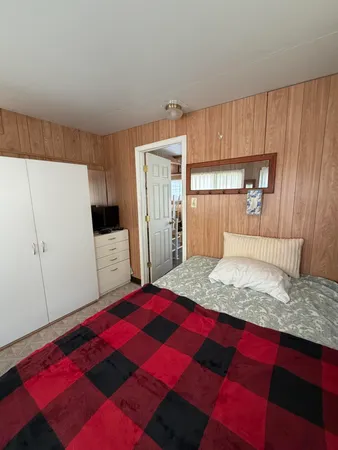 a bedroom with a bed and a large mirror on the dresser