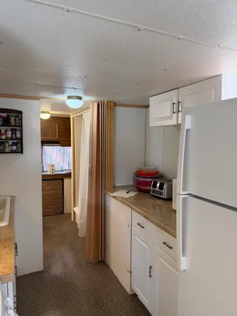 a kitchen with refrigerator and cabinets