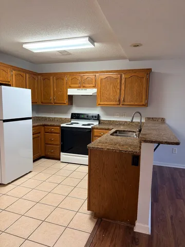 a kitchen with a sink a stove and a refrigerator